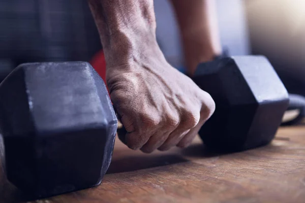 Mi sangre está hecha de bestia. Un disparo de un hombre irreconocible haciendo ejercicio con una mancuerna en el gimnasio. —  Fotos de Stock