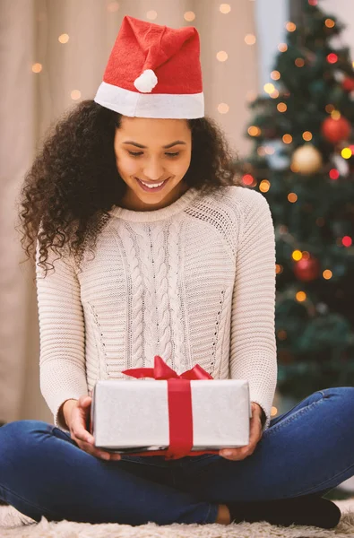 Noel hediyesinin kalbini mutlulukla doldurmasına izin ver. Mutlu genç bir kadının Noel 'de evde hediyeleri açması.. — Stok fotoğraf