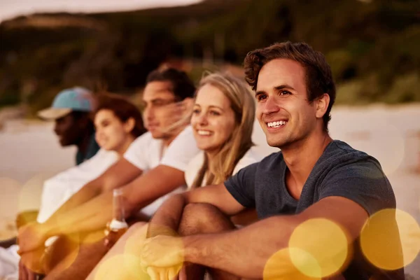 Bonitos lazos y hermosos paisajes. Recorte de un grupo de amigos sentados juntos en la playa. — Foto de Stock