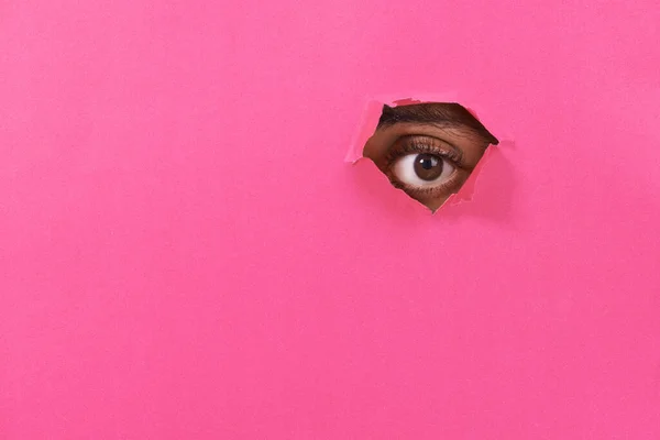 Látlak. A kilátás egy férfi szeme néz egy lyukon keresztül néhány színes papír. — Stock Fotó
