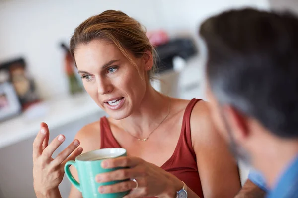 Ale to je přesně to, co říkám. Oříznutý záběr atraktivní mladé ženy s vážnou konverzaci s manželem, zatímco drží šálek kávy. — Stock fotografie