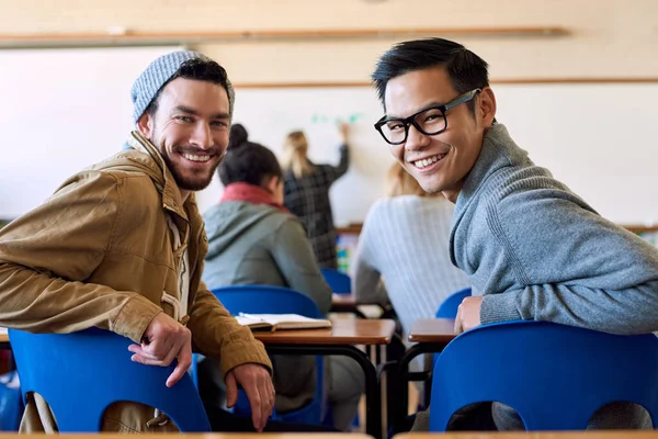 We zijn hier om te leren. Achteraanzicht portret van twee jonge mannelijke universiteitsstudenten in de klas tijdens een lezing. — Stockfoto