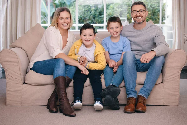 The wonders of family. Shot of a young family happily bonding together on the sofa at home.