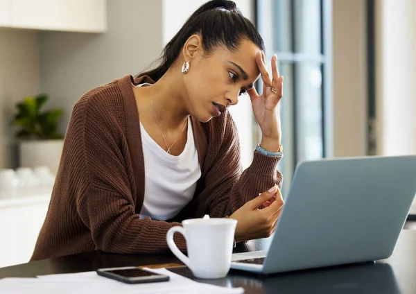 Trabajar desde casa seguro que es un dolor algunos días. Fotografía de una mujer joven que parece estresada mientras trabaja en su computadora portátil en casa. — Foto de Stock