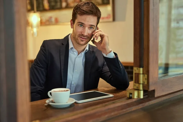 Sana geri döneyim... Bir kahve dükkanında otururken genç bir işadamının telefon görüşmesi yapması.. — Stok fotoğraf