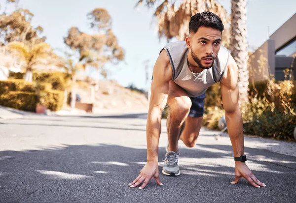 Ben zaten maratonları kazanmaya hazırım. Yakışıklı bir delikanlının uzun mesafeli çekimi dışarıda koşmadan önce belli bir pozisyonda çömelmiş.. — Stok fotoğraf