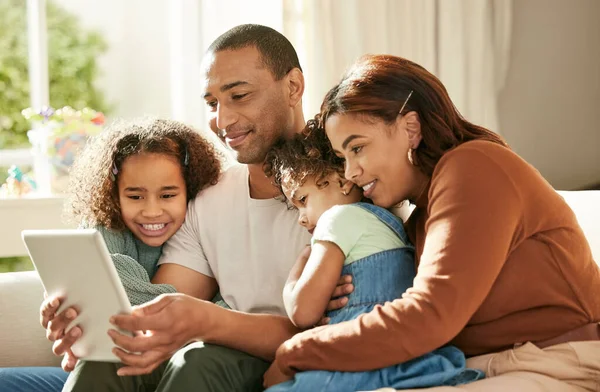 Familjen kommer först. Skott av en ung familj med hjälp av en digital surfplatta hemma. — Stockfoto