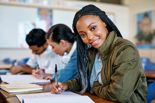 Lo hago por mi futuro. Retrato recortado de un joven y atractivo estudiante universitario tomando notas mientras está sentado en clase. —  Fotos de Stock