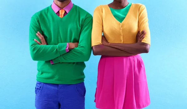 Estilo com uma atitude colorida. Estúdio recortado tiro de duas pessoas elegantemente vestidas de pé com os braços cruzados. — Fotografia de Stock