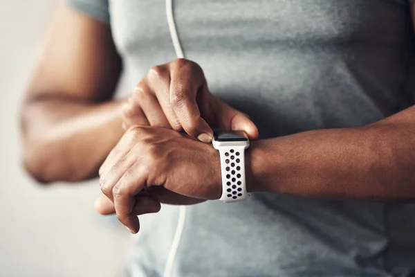 Los números prueban que estás progresando. Primer plano de un hombre irreconocible revisando su reloj de pulsera mientras hace ejercicio en casa. — Foto de Stock