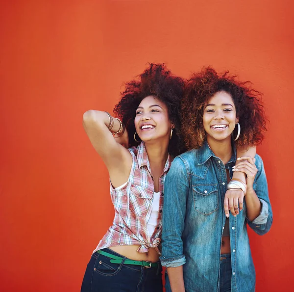 Los mejores amigos hacen los tiempos felices aún más felices. Foto de dos jóvenes amigos posando sobre un fondo rojo. —  Fotos de Stock