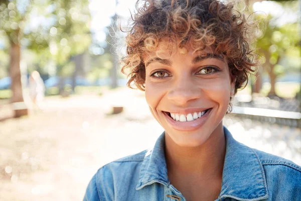 Sonríe en un día soleado. Retrato de una hermosa joven pasando el día al aire libre en un día soleado. — Foto de Stock