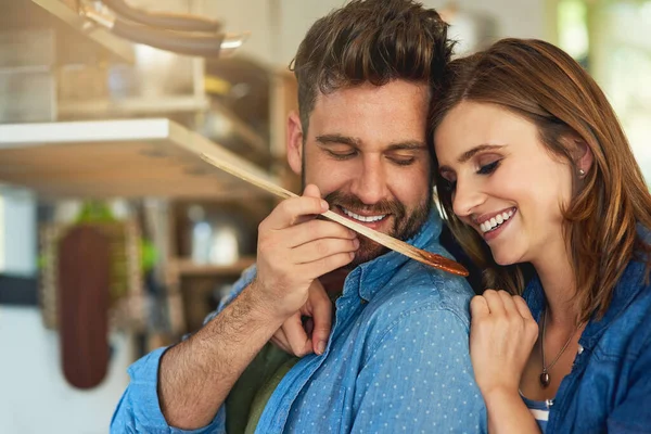 Alimentar su matrimonio con alimentos sabrosos y nutritivos. Un disparo de un hombre dando a su esposa un sabor de la comida que se prepara en casa. — Foto de Stock
