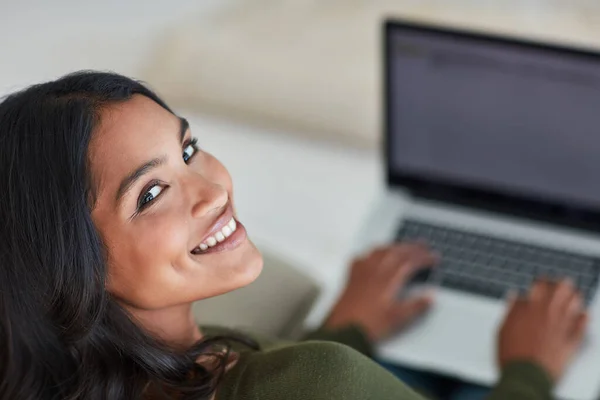 Ik ben altijd verbonden. Portret van een aantrekkelijke jonge vrouw met behulp van haar laptop terwijl ze thuis op de bank zit. — Stockfoto