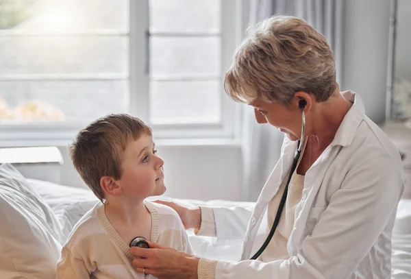 Zhluboka se nadechni. Postřelen doktorem, vyšetřen malý chlapec se stetoskopem v posteli doma. — Stock fotografie