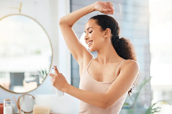Rimanere fresco tutto il giorno. Girato di una giovane donna che applica il deodorante alla sua ascella a casa. — Foto Stock