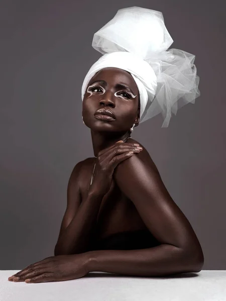 Style, c'est dire qui tu es sans parler. Plan studio d'une jolie jeune femme posant en tenue traditionnelle africaine sur fond gris. — Photo