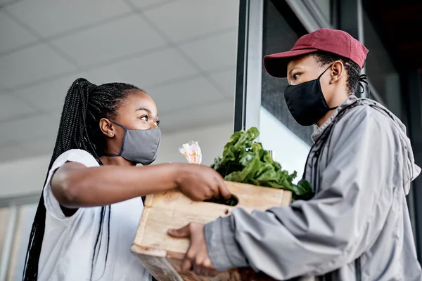 É como trazer a loja até ti. Tiro de um jovem mascarado entregando produtos frescos para um cliente em casa. — Fotografia de Stock