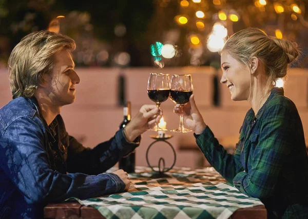 Nasza miłość to coś do picia. Ujęcie młodej pary wznoszącej toast na randce. — Zdjęcie stockowe