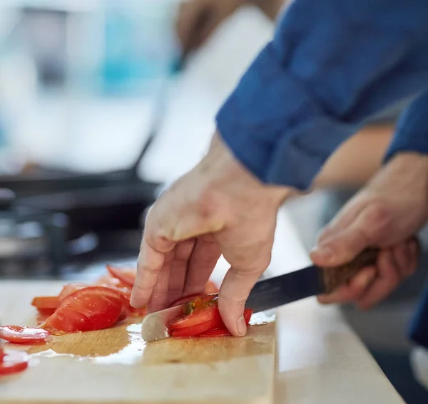 Cortando y cortando en cubitos. Un disparo de un hombre no identificable cortando tomates en su cocina en casa. —  Fotos de Stock