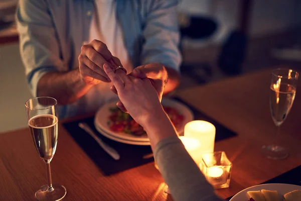 La ocasión perfecta. Recorte de un hombre irreconocible proponiéndole matrimonio a su esposa durante una cena encendida con velas por la noche. — Foto de Stock