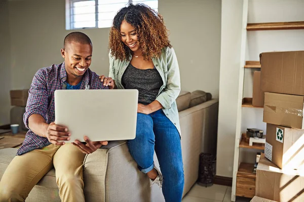 Что вы думаете об этом цвете стен. Съемка веселой молодой пары, делающей вместе покупки в интернете, сидя дома на диване. — стоковое фото