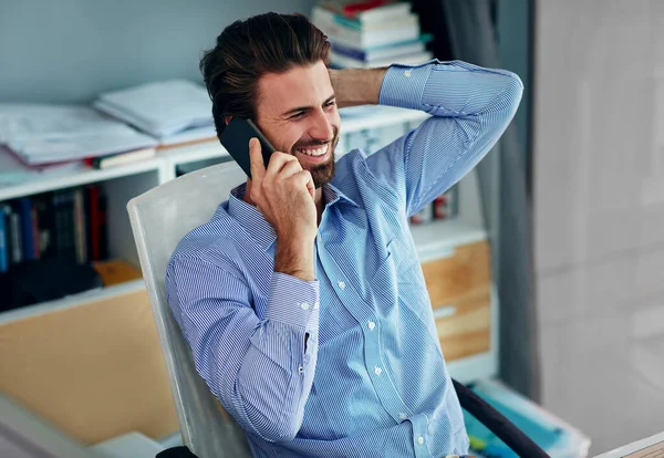 Dat is het nieuws waar ik op gewacht heb. Schot van een jonge zakenman aan het praten op een mobiele telefoon in zijn kantoor. — Stockfoto