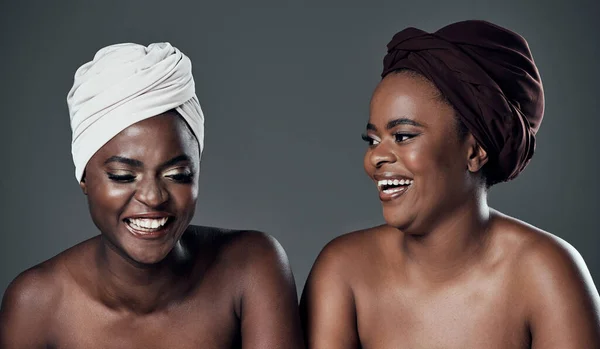 Verenig je in je verschillen. Studio shot van twee mooie jonge vrouwen poseren tegen een grijze achtergrond. — Stockfoto