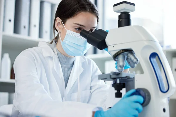 Zanurzam się w jej badaniach. Zdjęcie młodej kobiety używającej mikroskopu w laboratorium.. — Zdjęcie stockowe