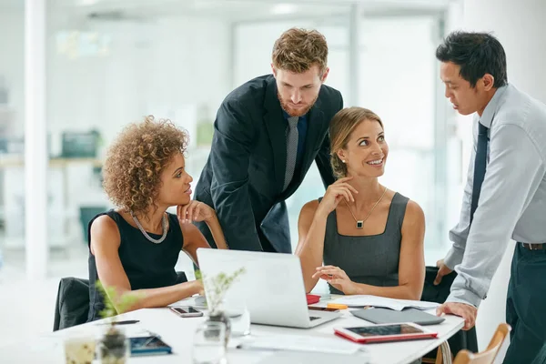 Het hardst werkende team in het bedrijfsleven. Opname van een groep zakenmensen die samen op een laptop werken in een modern kantoor. — Stockfoto