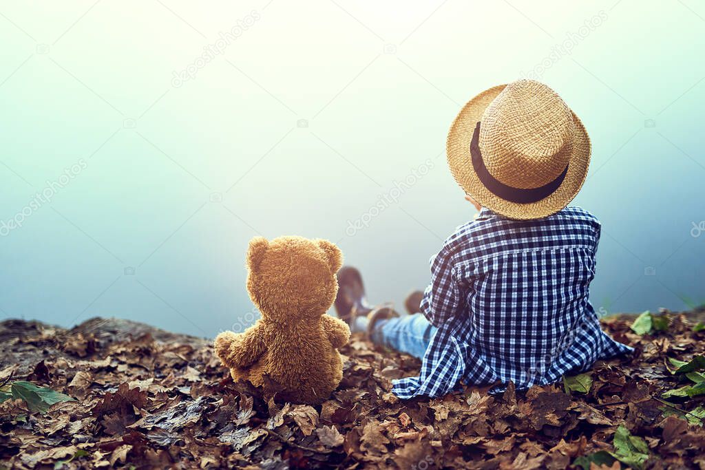 Hes got a friend in teddy. Shot of a little boy sitting in the forest with his teddy bear.