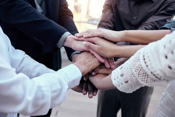 Ci vogliono solo due selci per accendere un fuoco. Girato di un gruppo di imprenditori irriconoscibili che si mettono insieme le mani fuori. — Foto Stock