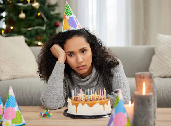 This was supposed to be my special day.... Shot of a young woman looking unhappy while celebrating her birthday alone at home.