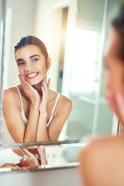 Su belleza natural brilla. Fotografía de una joven atractiva inspeccionando su piel en el espejo. — Foto de Stock