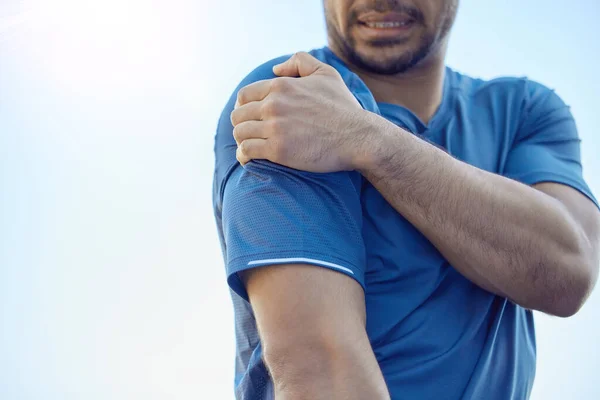 Me disloqué el hombro. Recortado tiro de un hombre irreconocible de pie solo y que sufre de dolor de hombro durante su entrenamiento al aire libre. — Foto de Stock