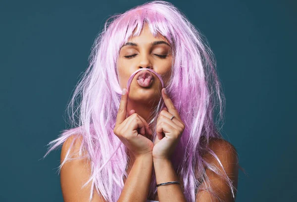Obedezca sus reglas, pierda la diversión. Estudio de una hermosa joven posando con una peluca rosa juguetona sobre un fondo azul. — Foto de Stock