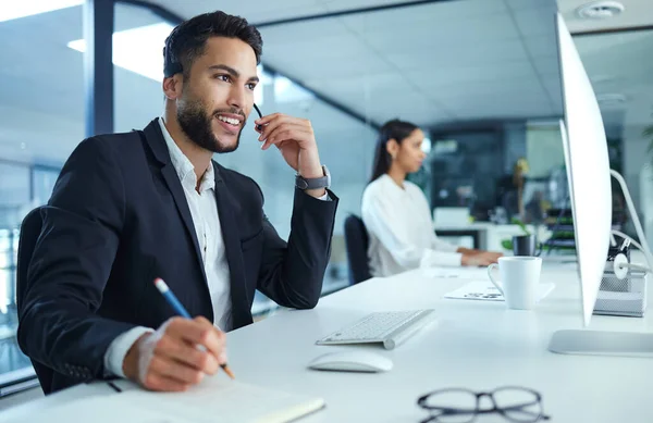 Welkom hoe ik u kan helpen. Een foto van een jonge zakenman die in een callcenter werkt.. — Stockfoto