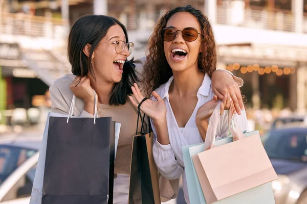 On va être fauchés, mais qui s'en soucie ? Tourné de deux jolies jeunes femmes debout dehors ensemble et collant tout en faisant du shopping dans la ville. — Photo