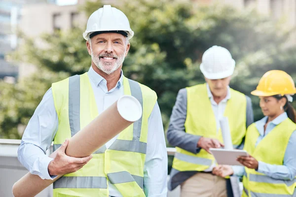 Het wordt groter dan je je ooit had voorgesteld. Portret van een zelfverzekerde volwassen zakenman met blauwdrukken tijdens het werken op een bouwplaats. — Stockfoto