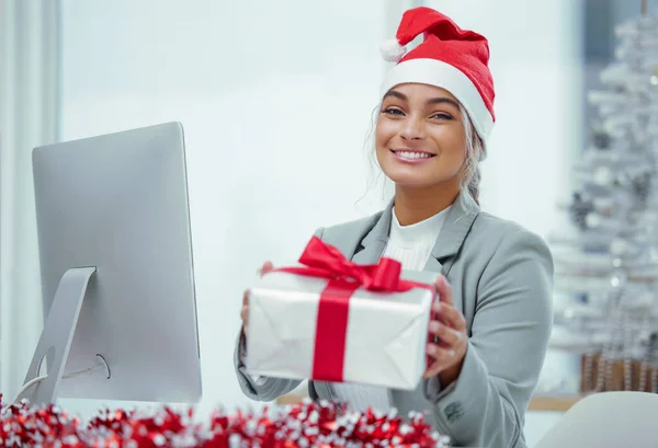 Neatly wrapped Christmas cheer. Portrait of a young beautiful woman spreading Christmas cheer with gifts at the office. — Stock Photo, Image