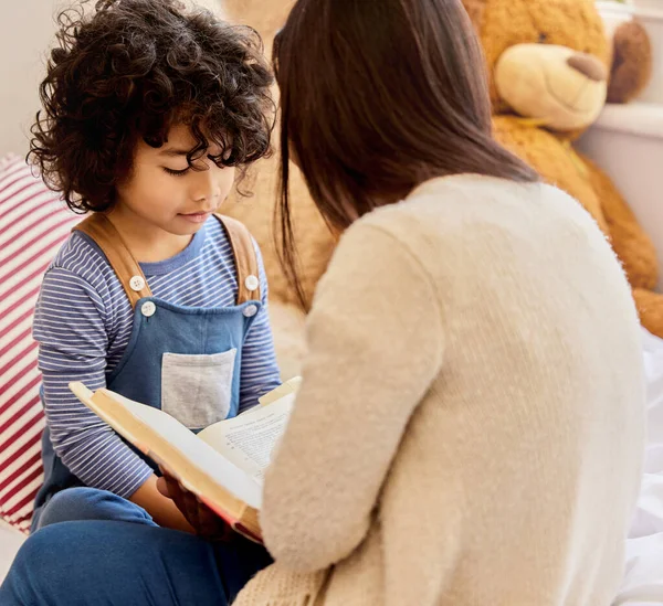 これは彼のお気に入りの話です。小さな男の子と彼の母親のショット一緒に家で読む. — ストック写真