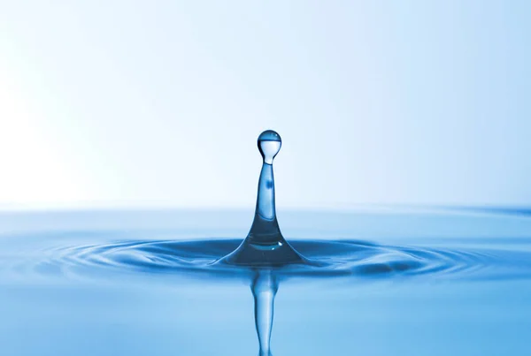 No drop too big, no drop too small. Abstract studio shot of a water droplet falling into a puddle of water. — Stock Photo, Image