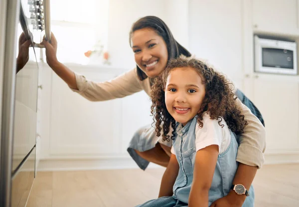 Vi kan inte vänta med att visa dem för dig. Skjuten av en liten flicka och hennes mamma sitter framför ugnen. — Stockfoto