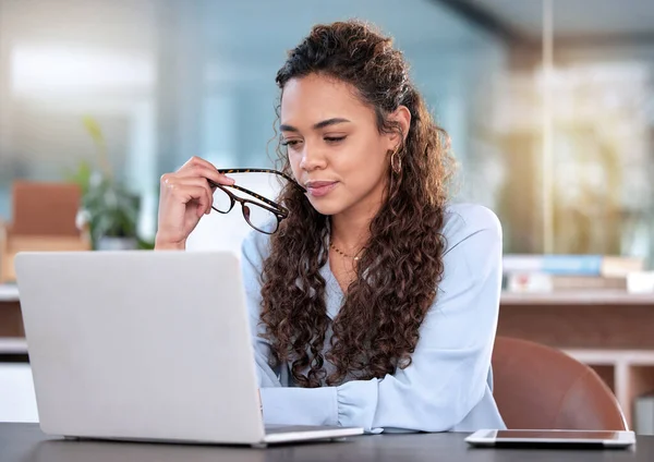 Przemyślałem to dokładnie. Ujęcie atrakcyjnej młodej bizneswoman wyglądającej troskliwie podczas pracy nad laptopem w biurze. — Zdjęcie stockowe