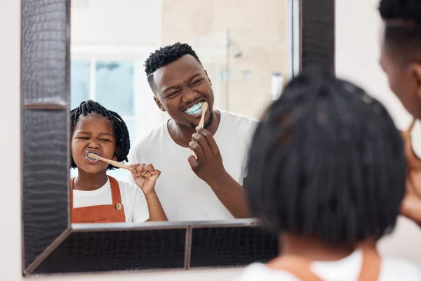 Переконайтеся, що у вас є кожен зуб. Постріл молодого батька, що зв'язується з дочкою, поки вони чистять зуби у ванній вдома . — стокове фото