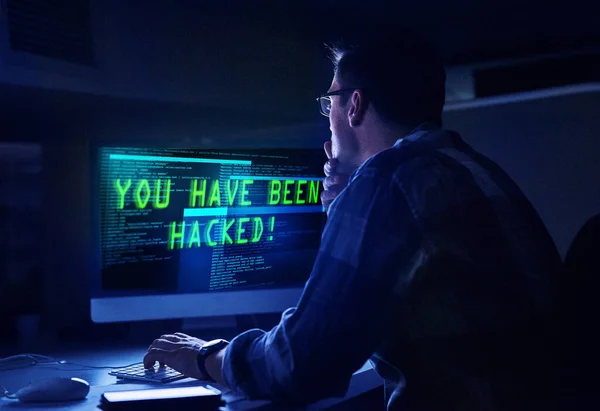 Hij weet hoe hij een hacker moet aanpakken. Rearview shot van een jonge mannelijke hacker op het werk. — Stockfoto