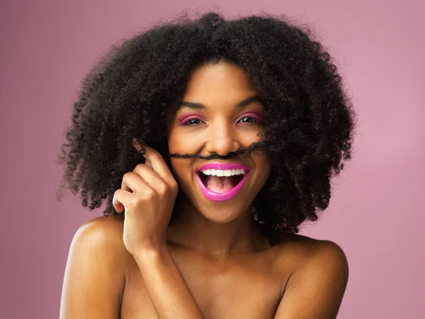 Niets is aantrekkelijker dan gevoel voor humor. Studio shot van een aantrekkelijke jonge vrouw poseren tegen een roze achtergrond. — Stockfoto
