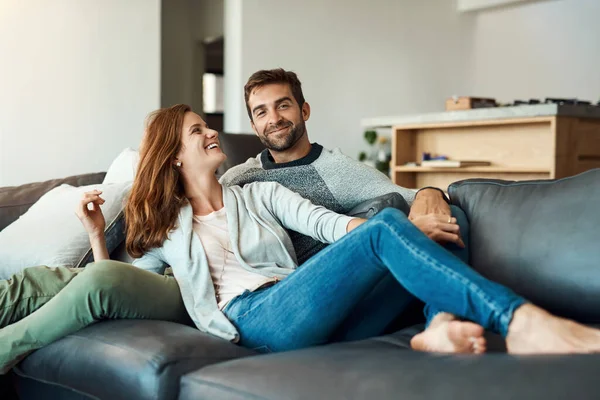 Mon week-end a officiellement commencé. Plan complet d'un jeune couple affectueux se relaxant sur leur canapé à la maison. — Photo