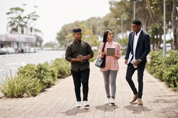 Os seus sistemas estão todos ligados. Tiro de um grupo de jovens empresários que têm um encontro enquanto caminham pela cidade. — Fotografia de Stock