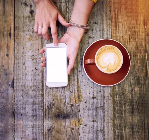 커피를 마시고 대화에 참여하 십시오. 여자가 핸드폰을 사용하고 커피를 마시는 높은 각도의 사진. — 스톡 사진